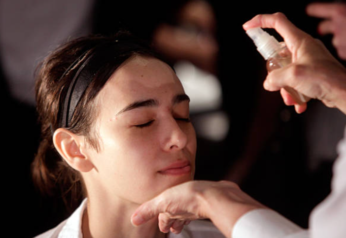 Applying setting spray to help make makeup last longer